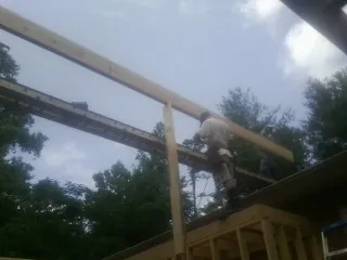 Carpenter setting a ridge beam over a new addition frame — Ice Dam Removal by Roofing Brothers in Bellwood