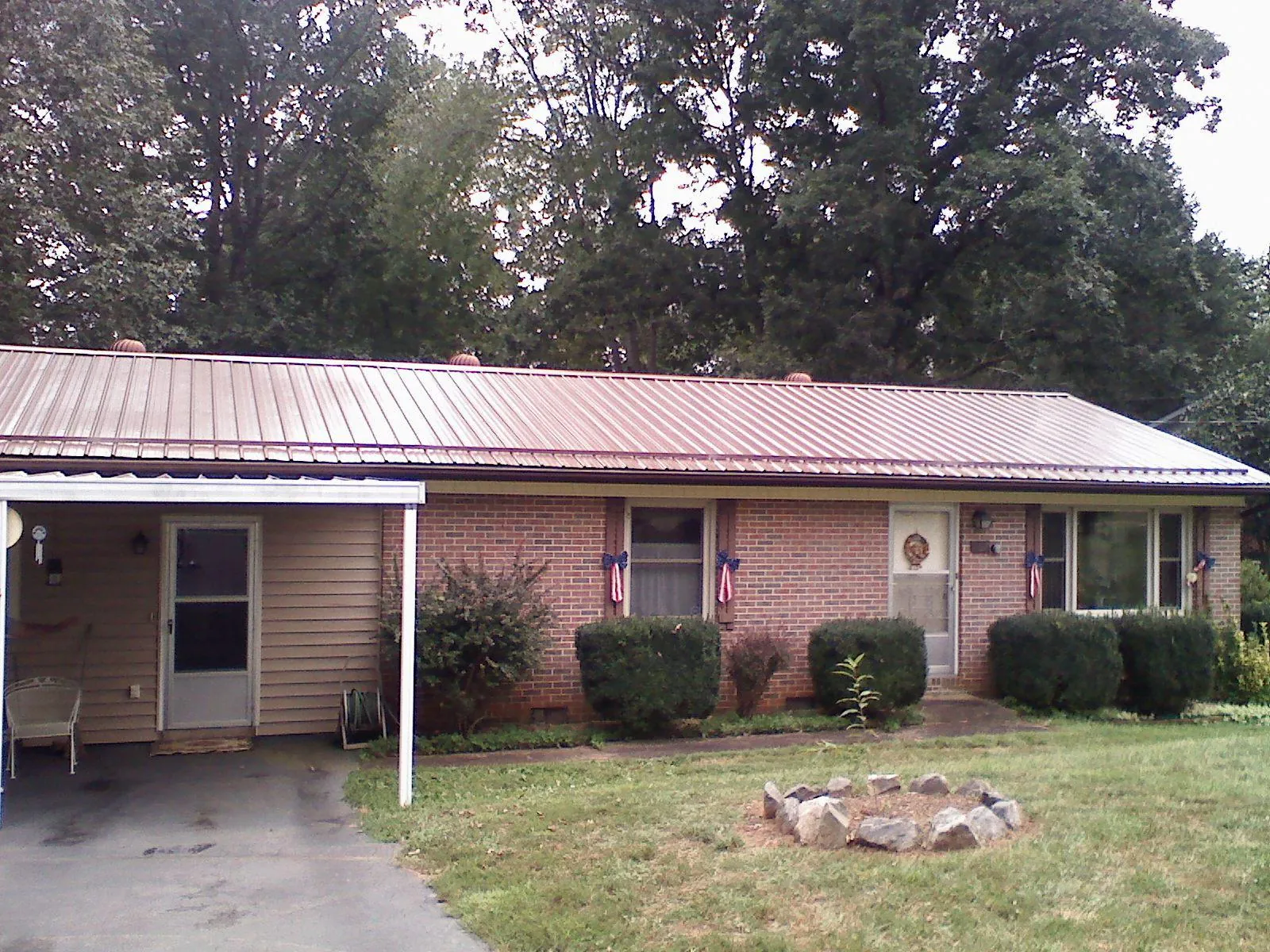 Bronze metal roof and carport on a brick ranch home — Roof Repair work by our crew in Bellwood